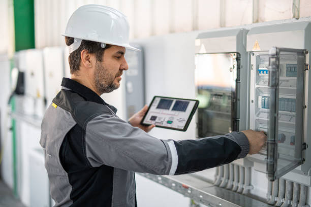 Kỹ thuật viên kiểm tra trạng thái inverter và hệ thống điện mặt trời bằng máy tính bảng